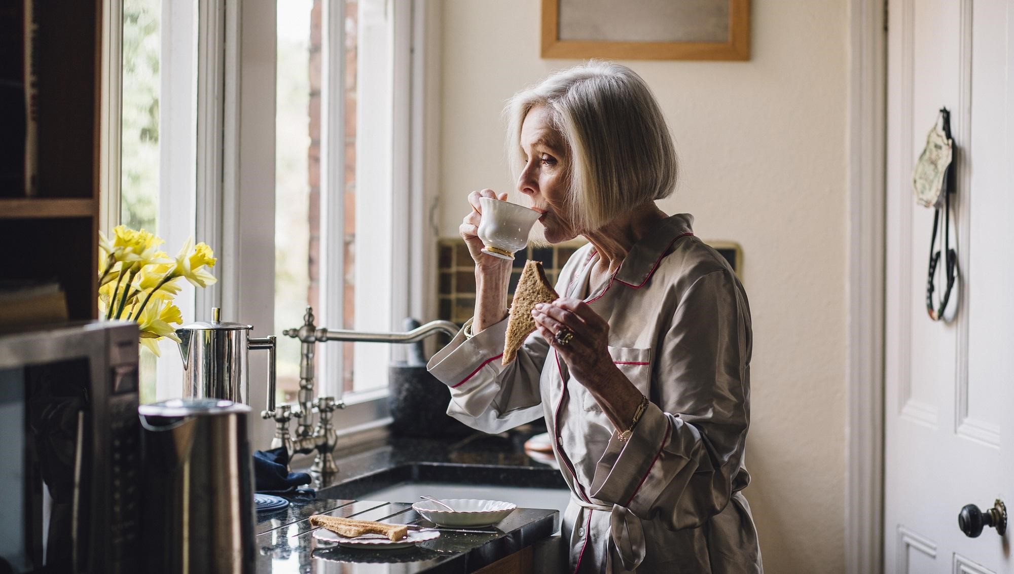 An older woman wearing a silk dressing gown.