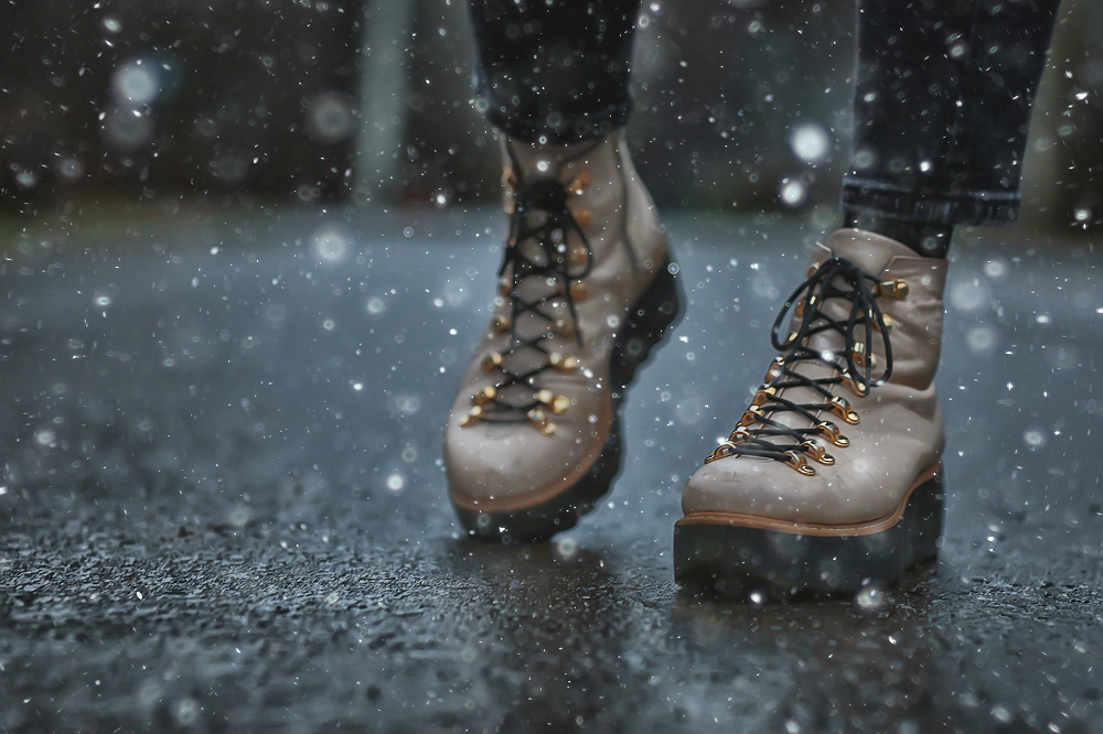 A woman wearing winter boots in the rain. 