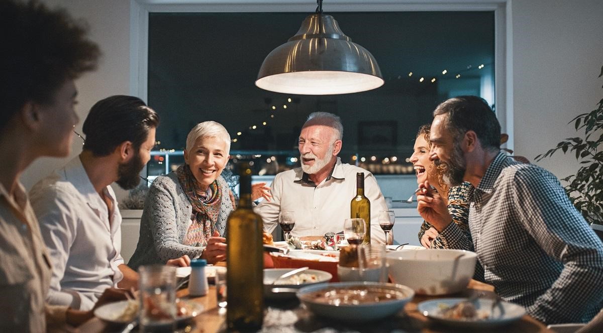 An over 60s couple having Christmas dinner with friends and family.