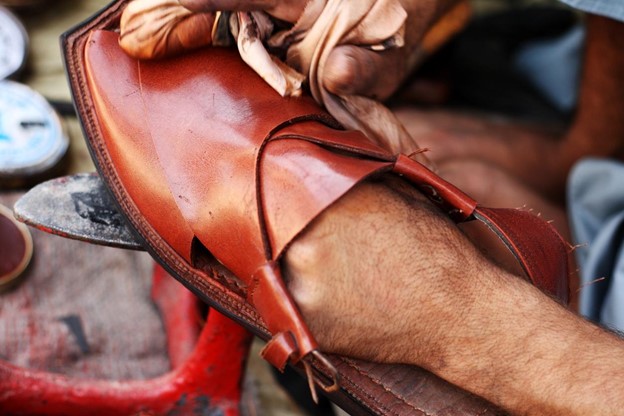 a man cleaning a leather sandal