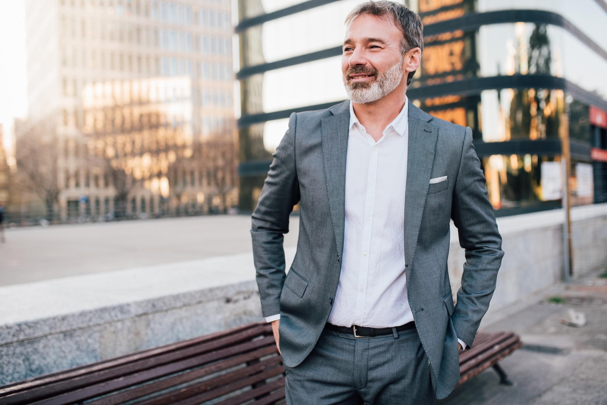 Older man in a suit with his shirt tucked in