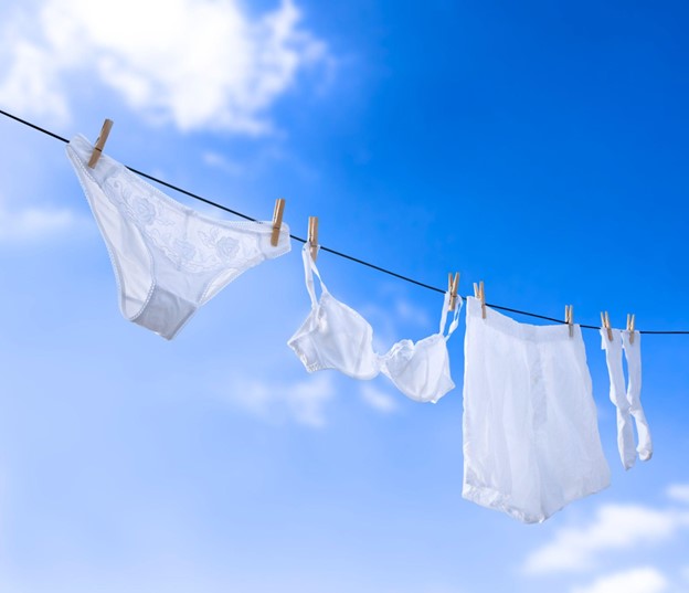 white underwear hanging on an outdoor washing line.